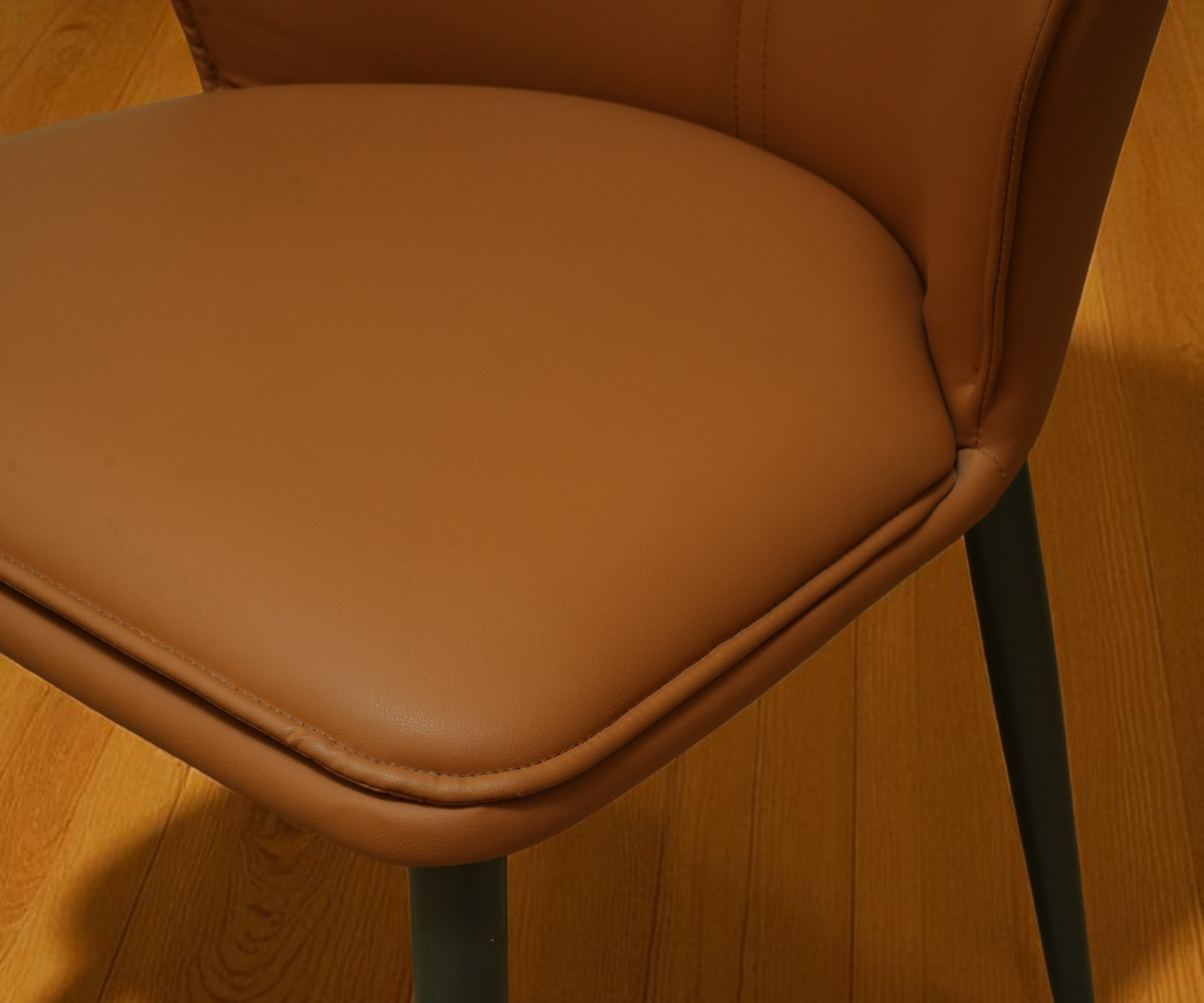 046 leather curved accent chair in tan, front view against a panelled wall