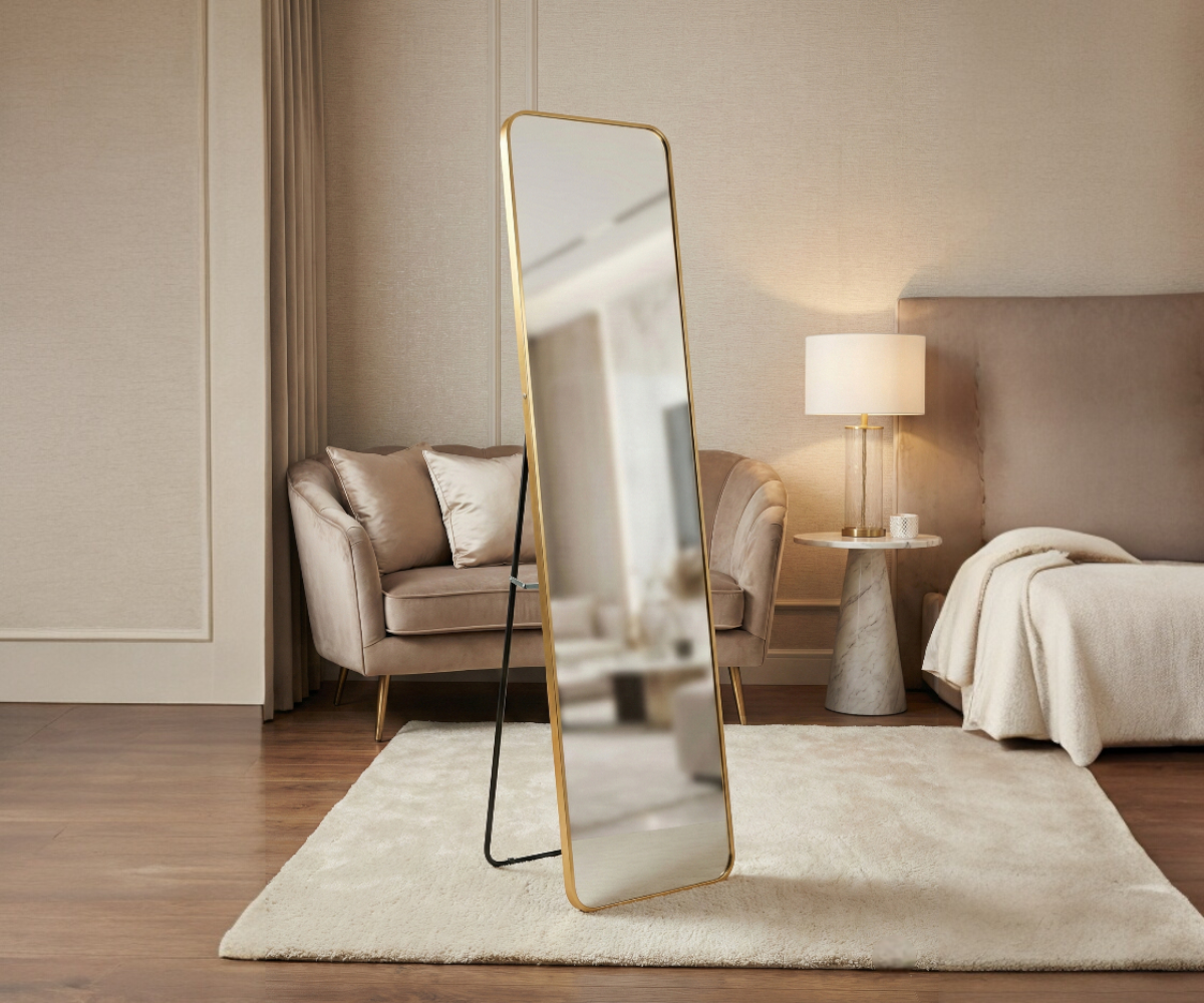 058 gold standing mirror in a warm-lit bedroom with an armchair