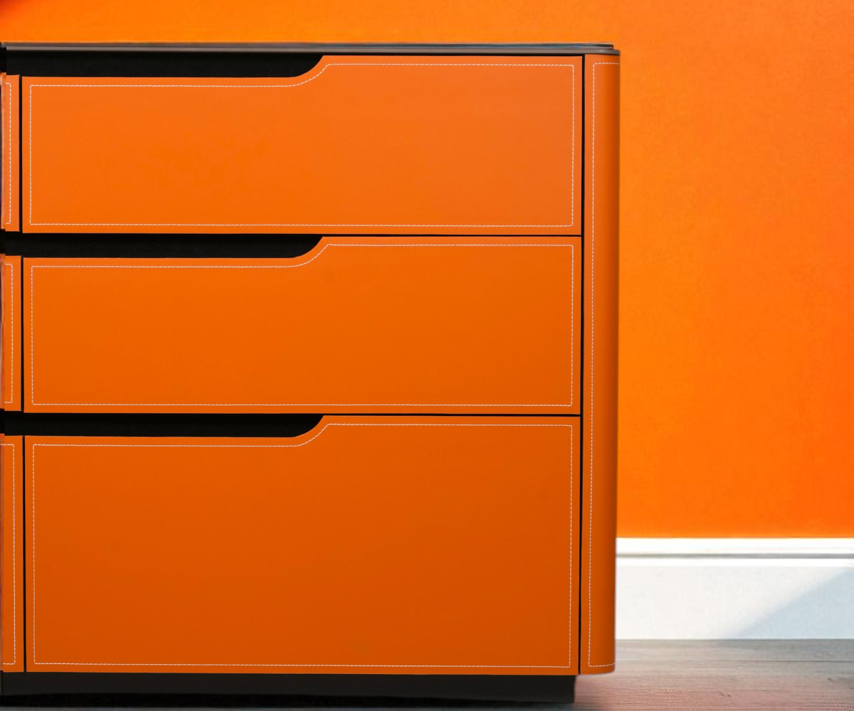 2002 orange drawer cabinet beside a plant in a bright room