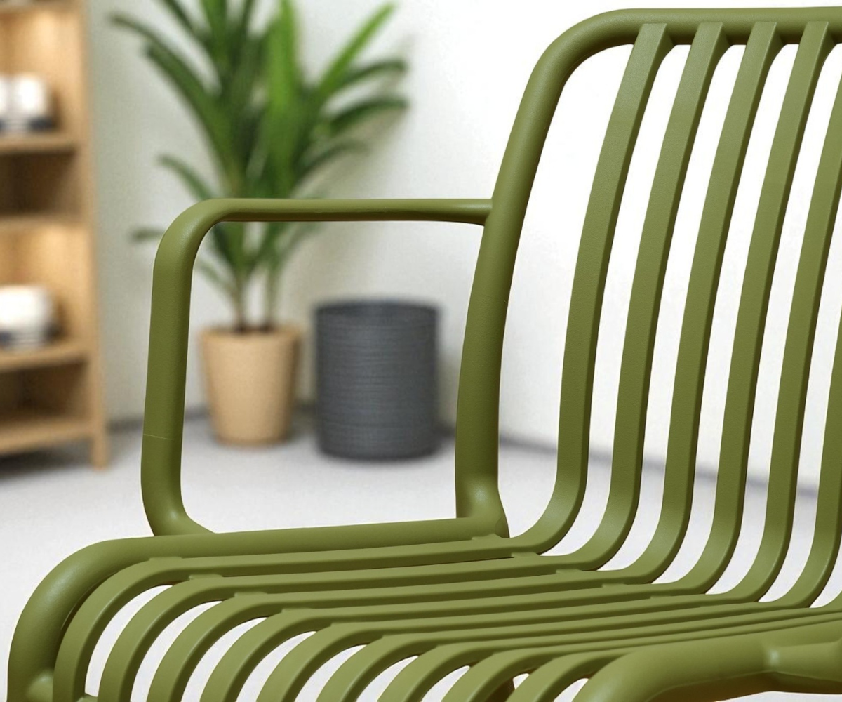 7102 ribbed designer patio chair in olive, in a white room beside a snake plant
