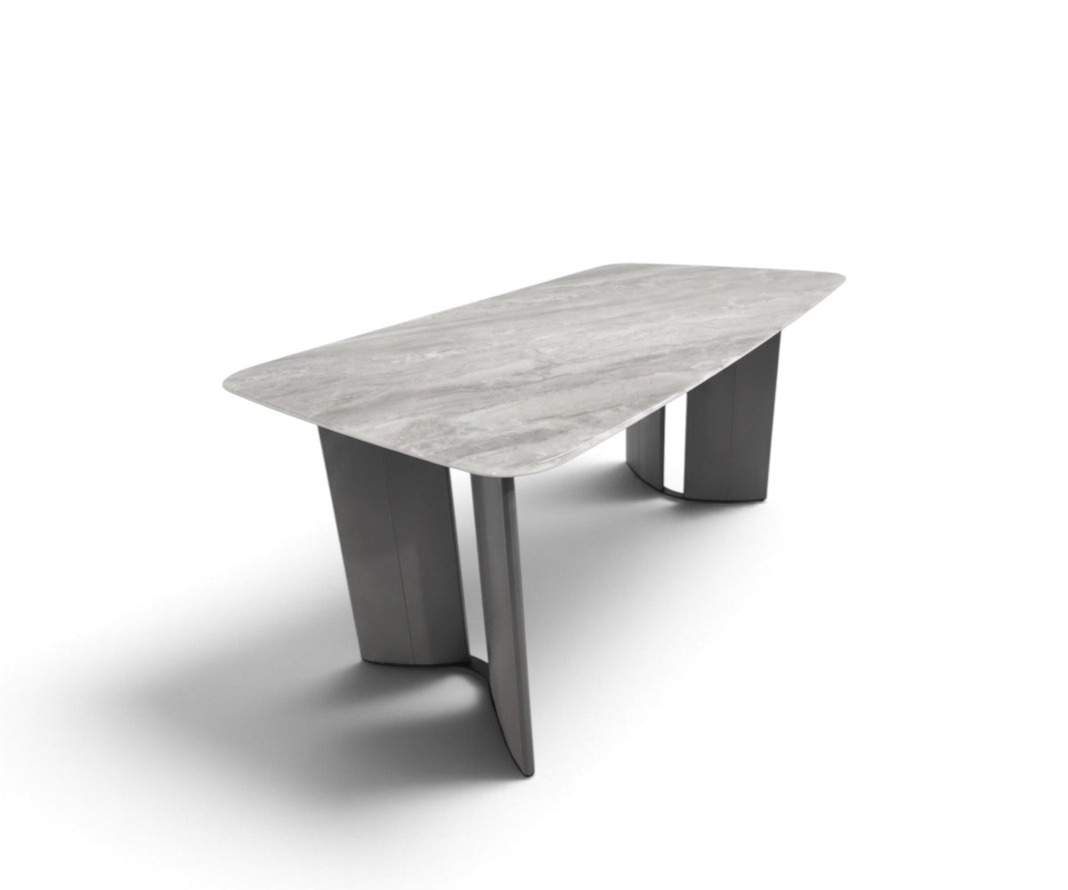 Grey stone-top dining table with twin sculptural satin metal pedestals