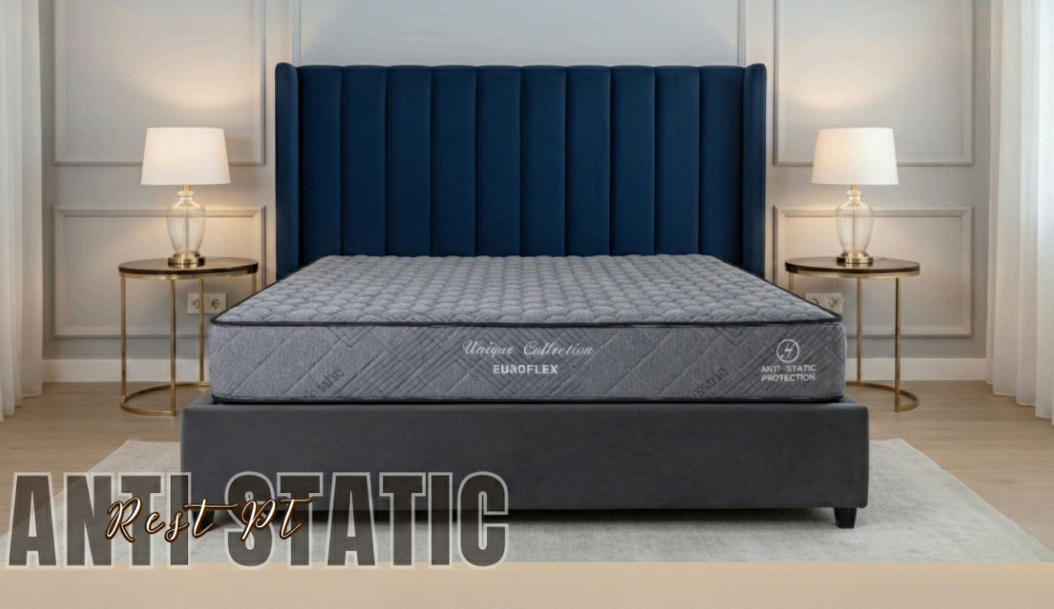 Anti Static mattress in grey with a dark border, on a bed base with a navy channel headboard