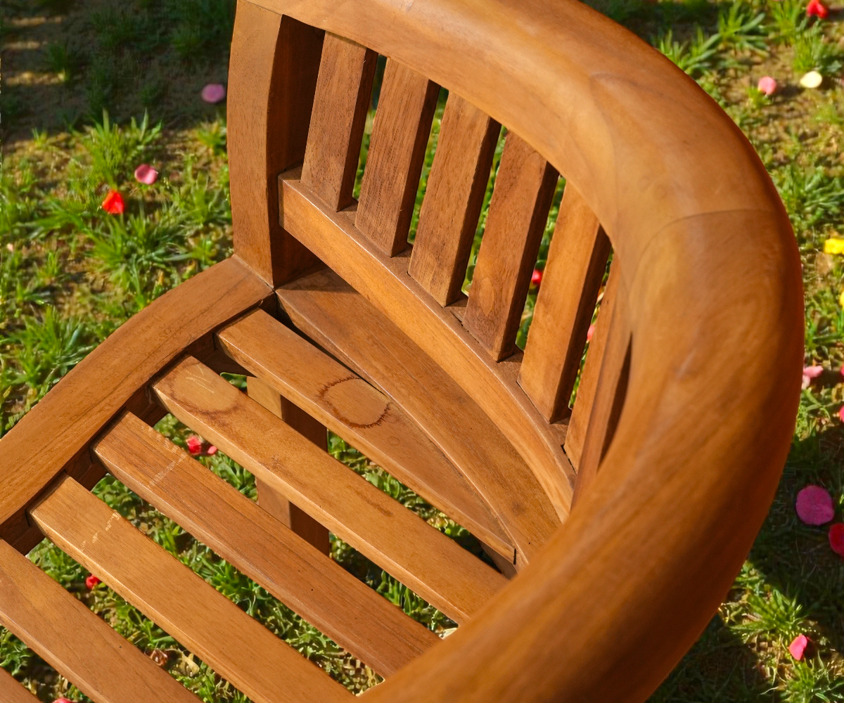 Banana bench set, curved teak bench and armchair on a manicured lawn