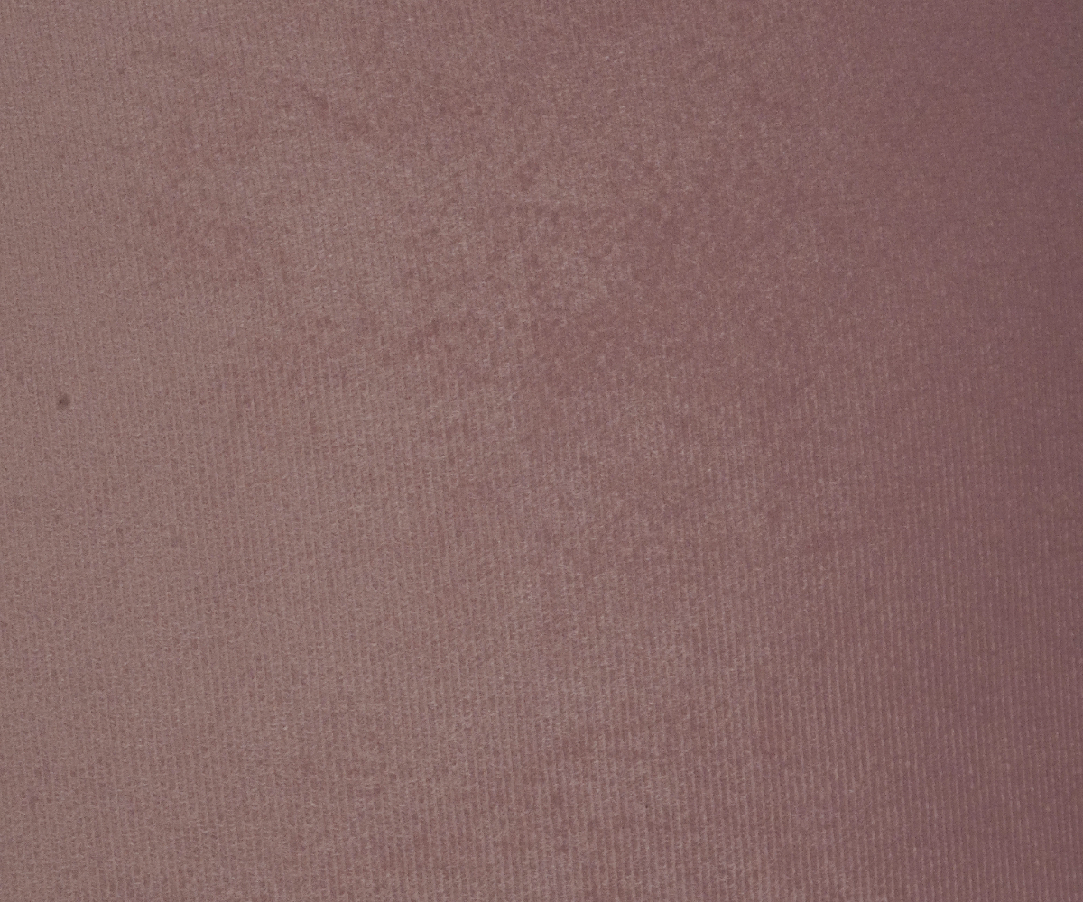 Blush bubble texture cushion cover on a teal sofa in a grey panelled room
