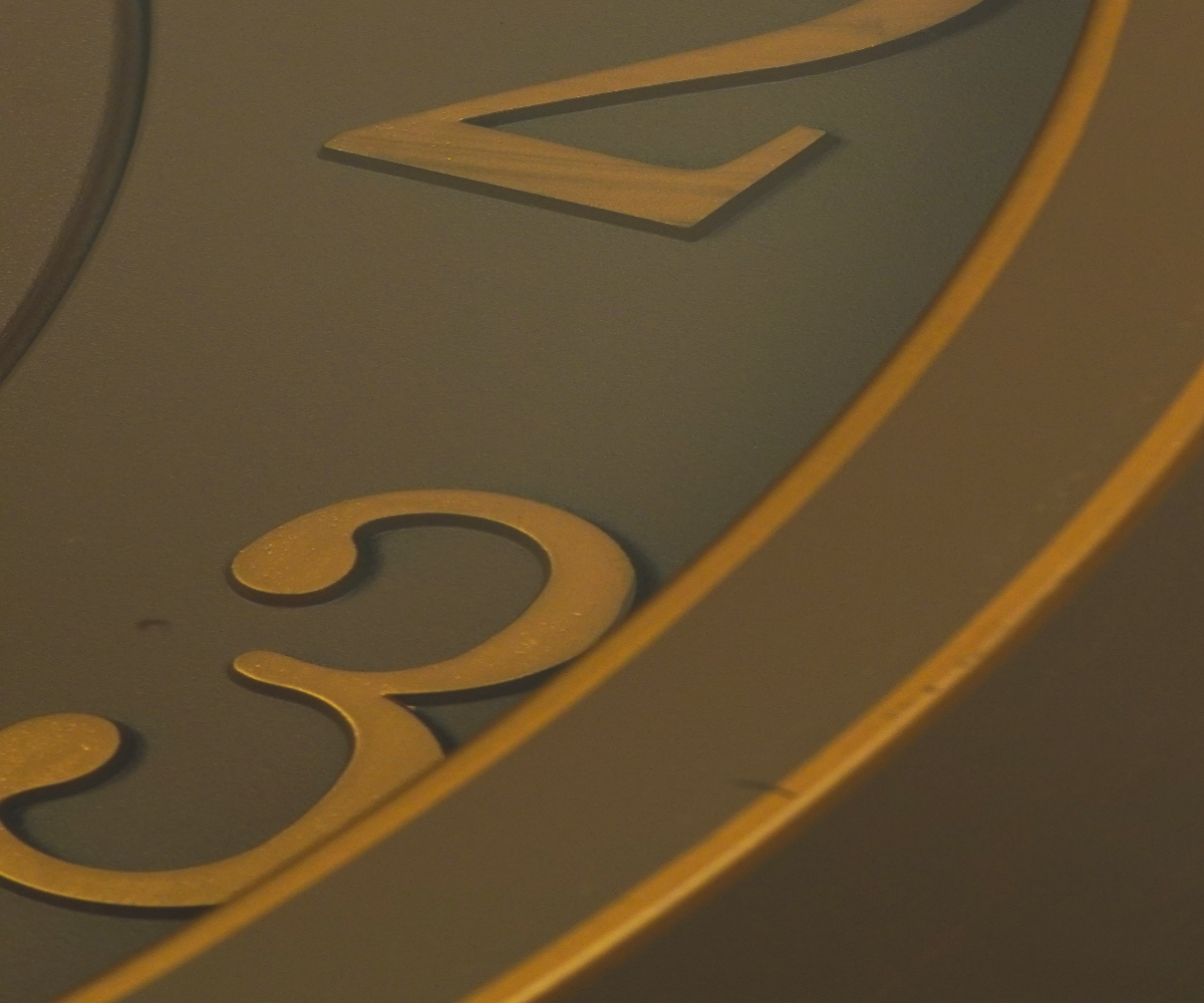Bronze gear skeleton wall clock on a table in a warm-lit room