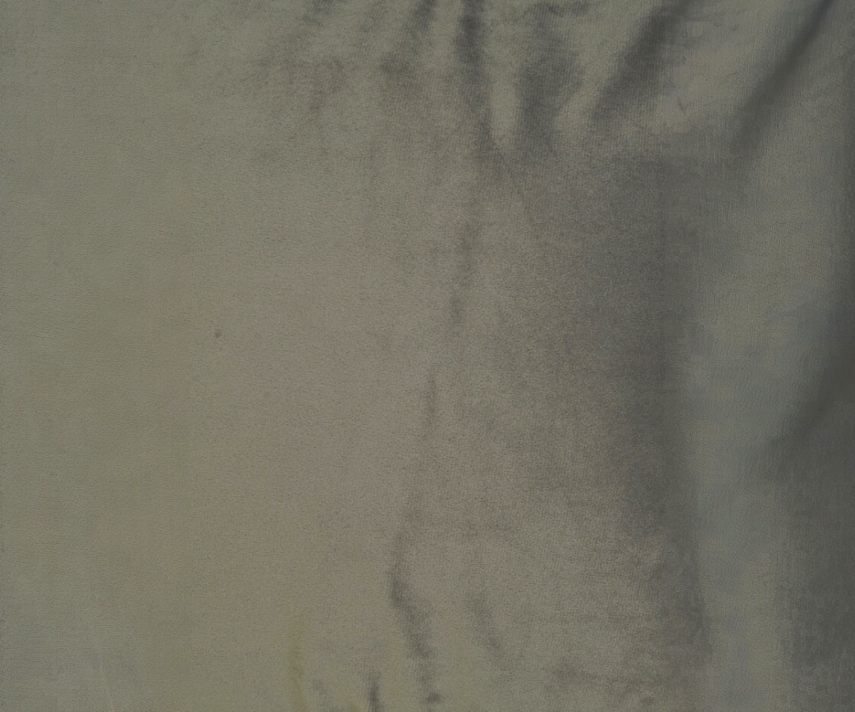 Charcoal ribbed velvet cushion cover on a grey sofa in a dark panelled room