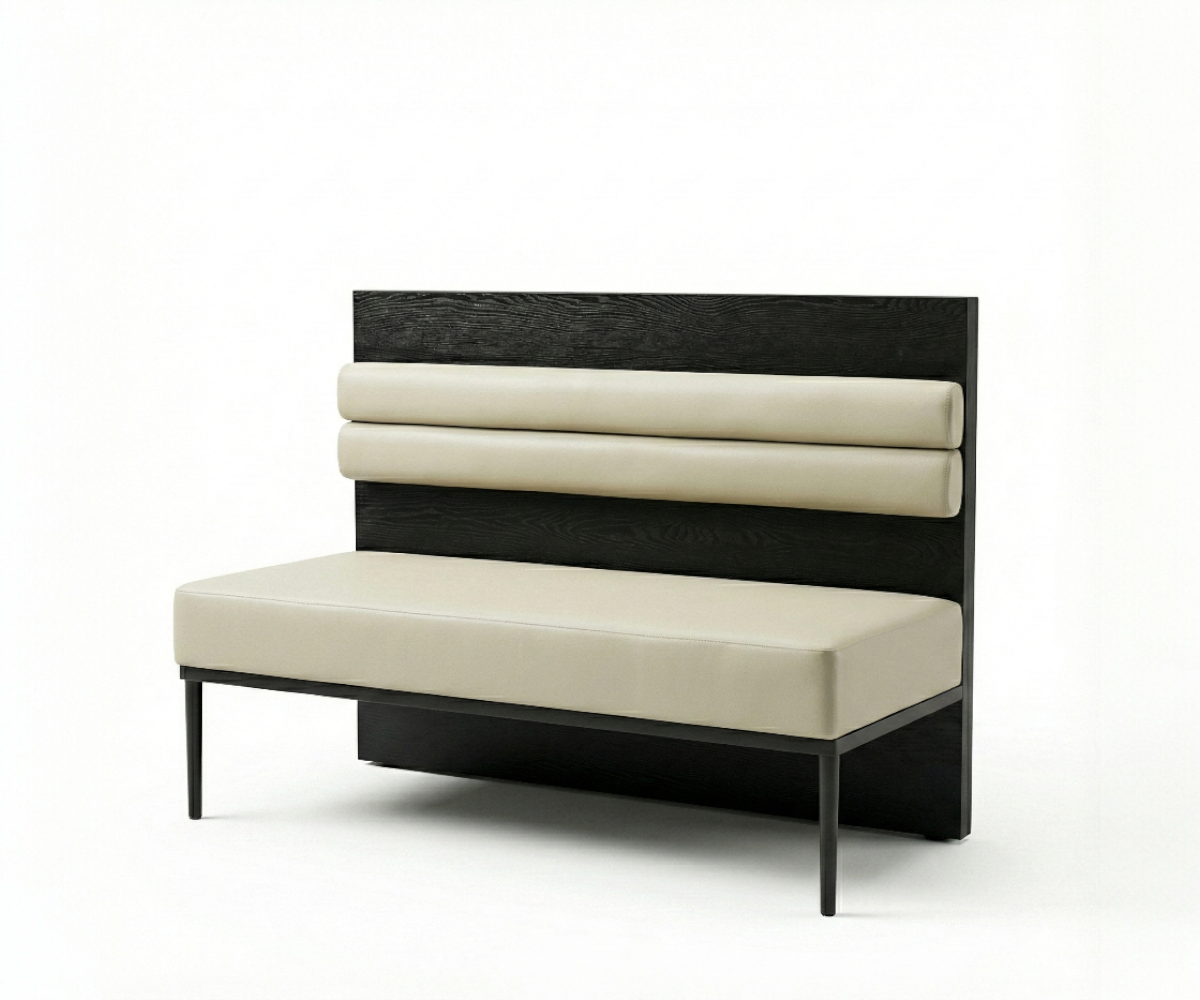 Contour banquette in a lit restaurant beside a terrazzo floor and open kitchen