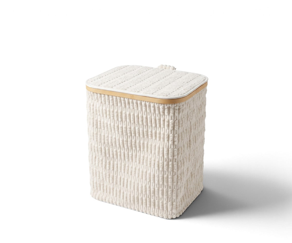 Cream ribbed laundry basket with fitted lid styled in a luxurious, well-lit modern dressing room