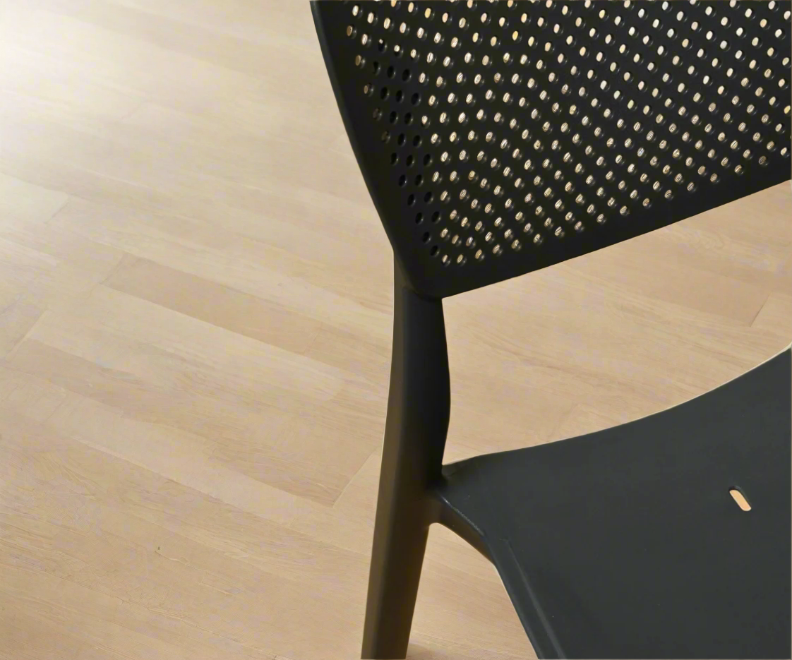 CT035 black perforated lifestyle chair, angled view on a light wood floor