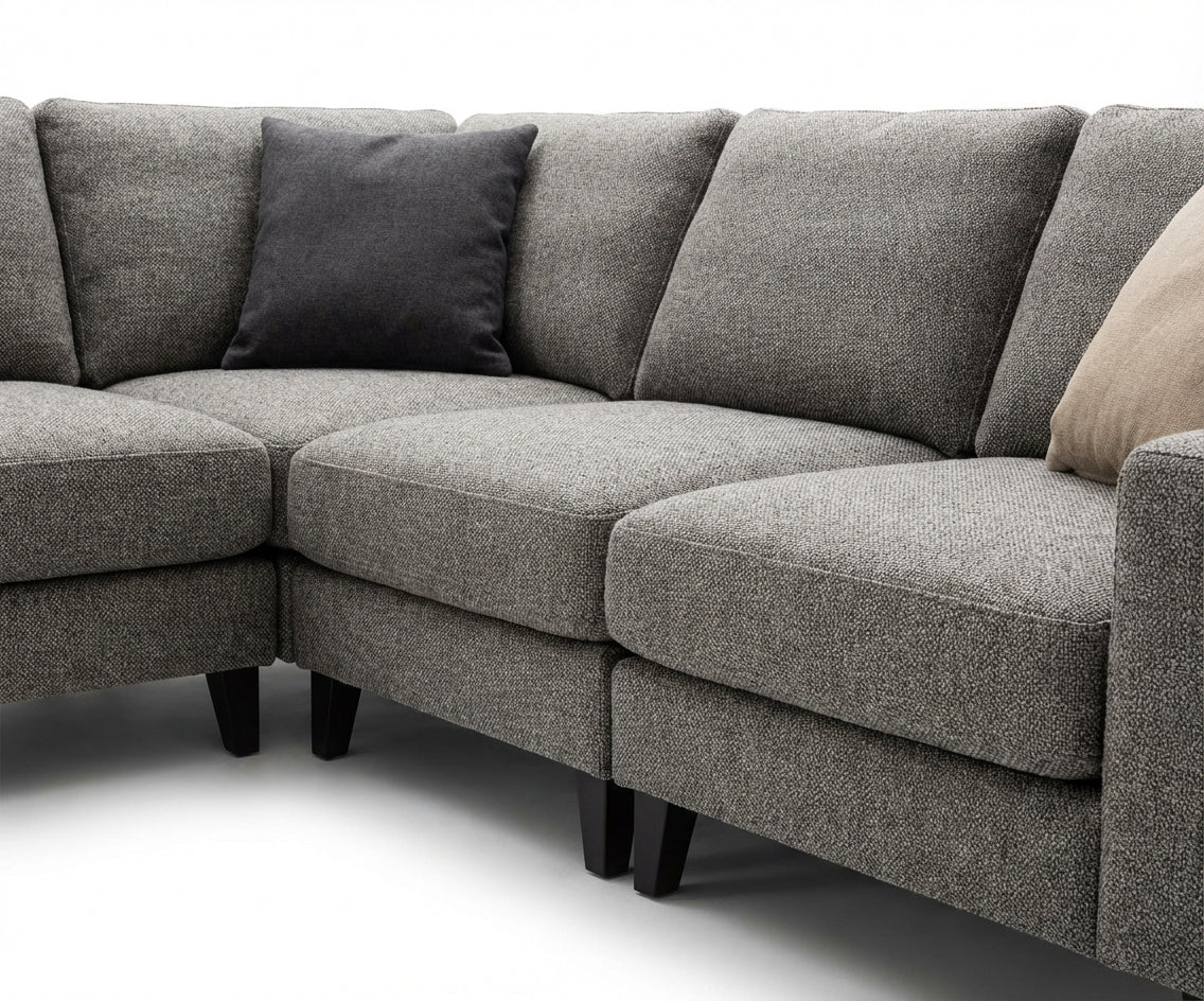 EXENCE grey corner sofa with ottoman in a bright garden-view living room