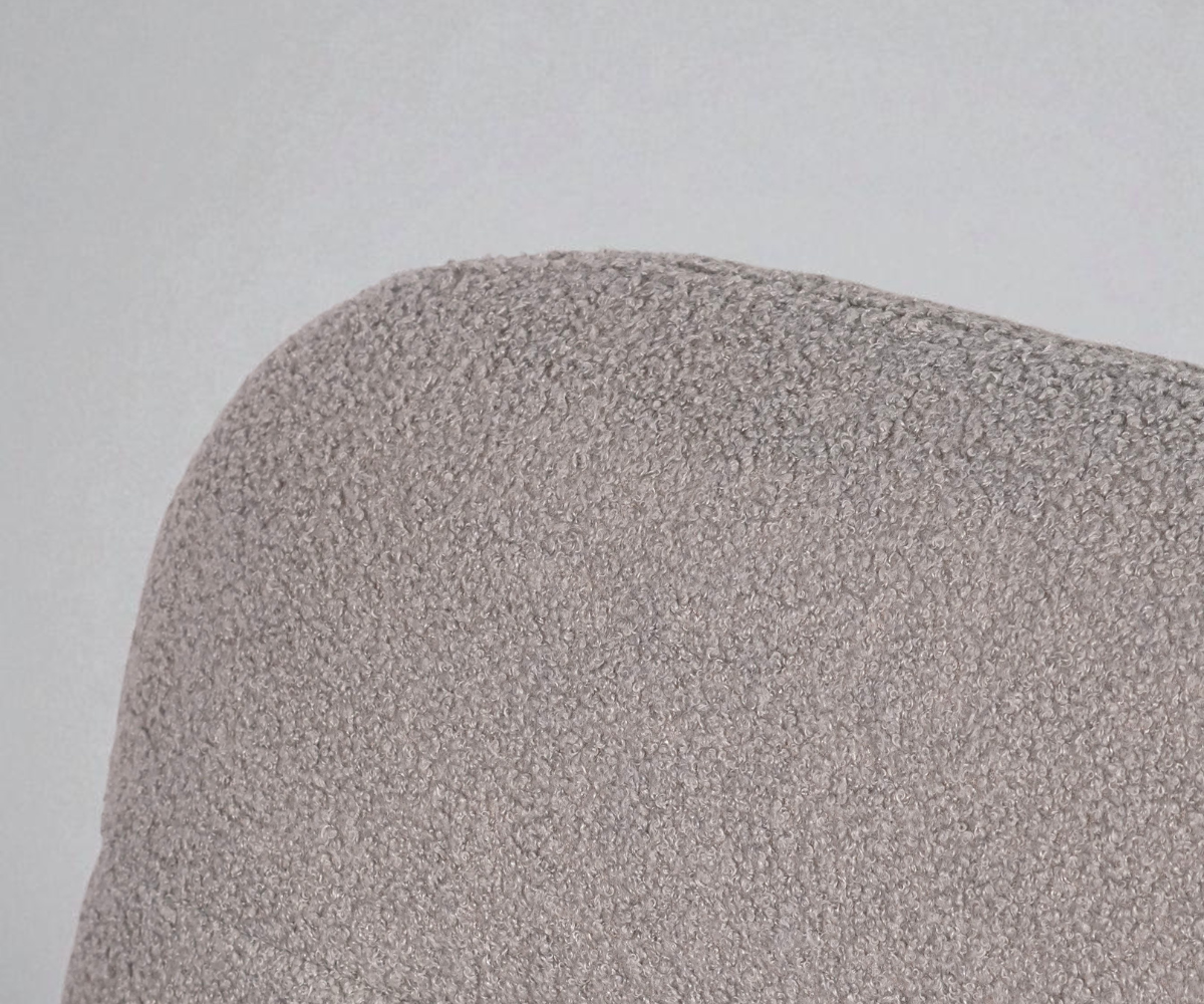 FALKEN beige boucle lounge armchair beside a fireplace and brass lamp