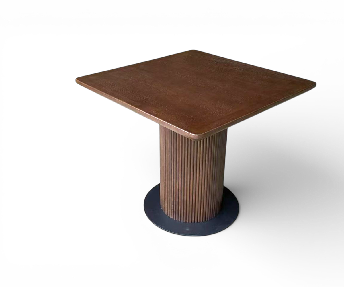 Fluted pedestal table in a warm restaurant with marble flooring