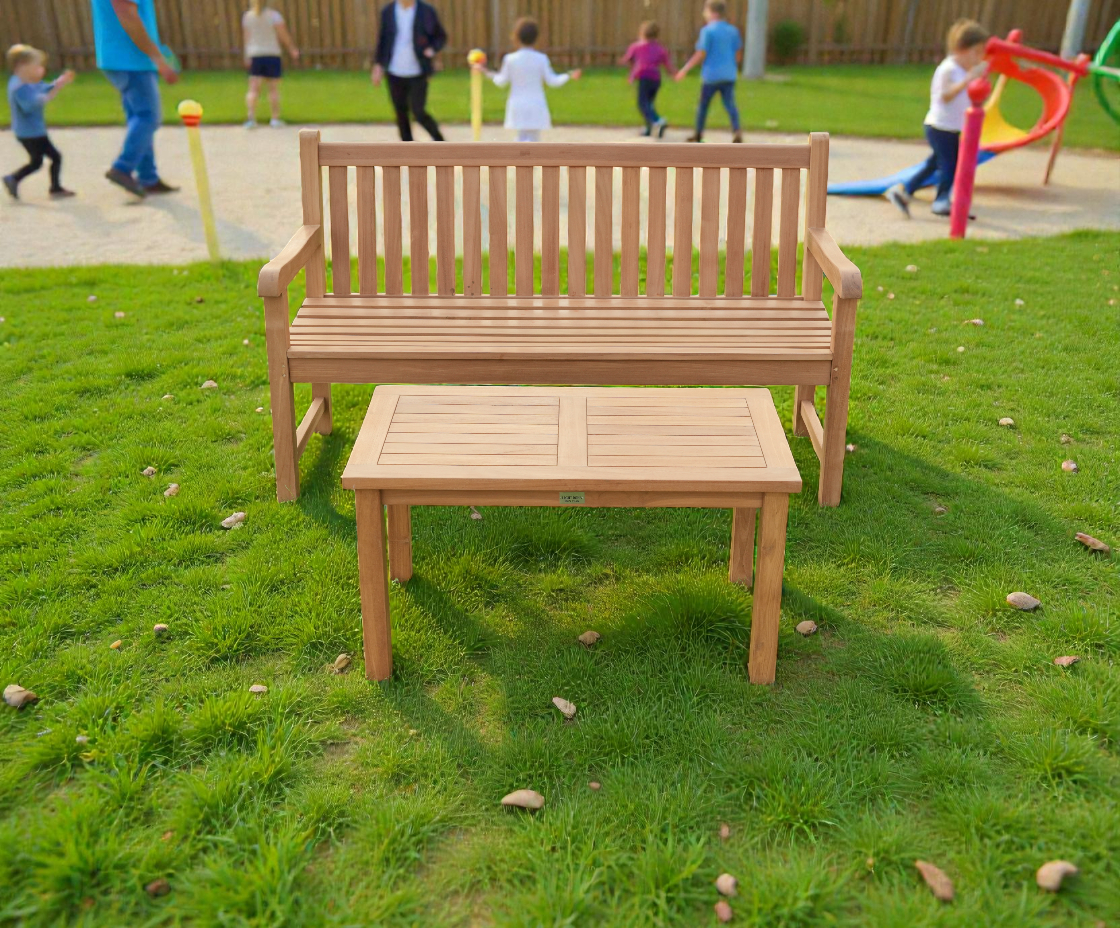 Garden bench straight, teak bench and table on a lawn beside a playground