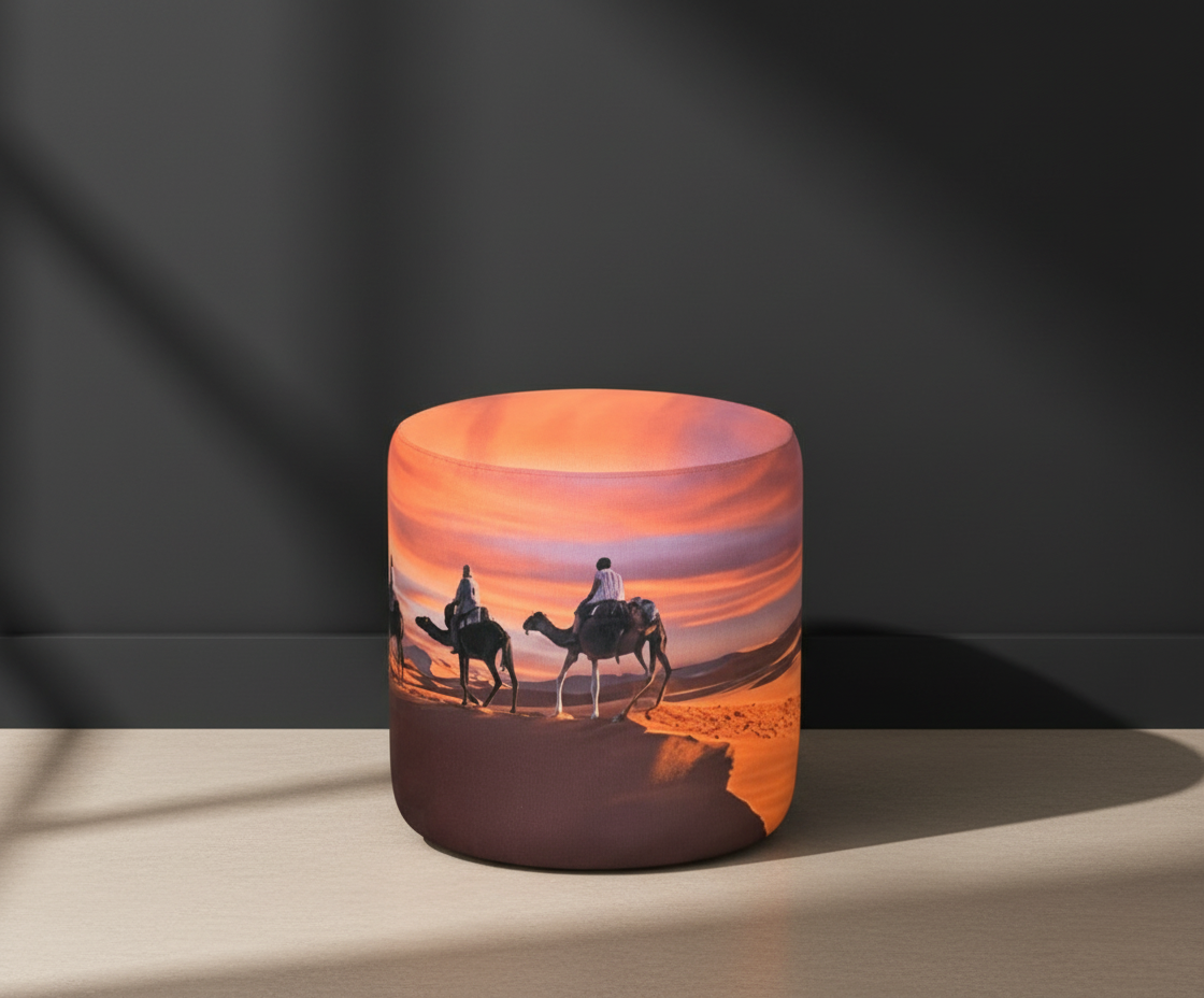 IDL round upholstered ottoman printed with a desert caravan at sunset
