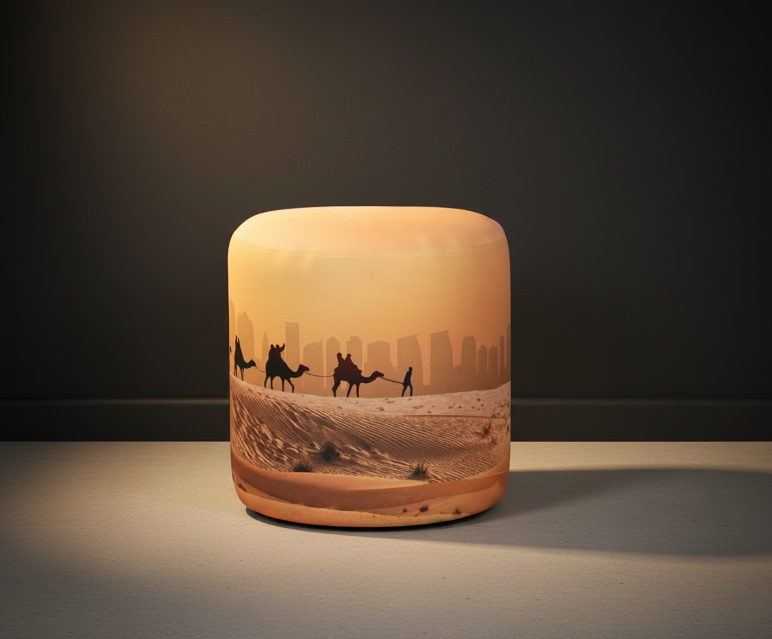 IDL round upholstered ottoman printed with a desert caravan at sunset