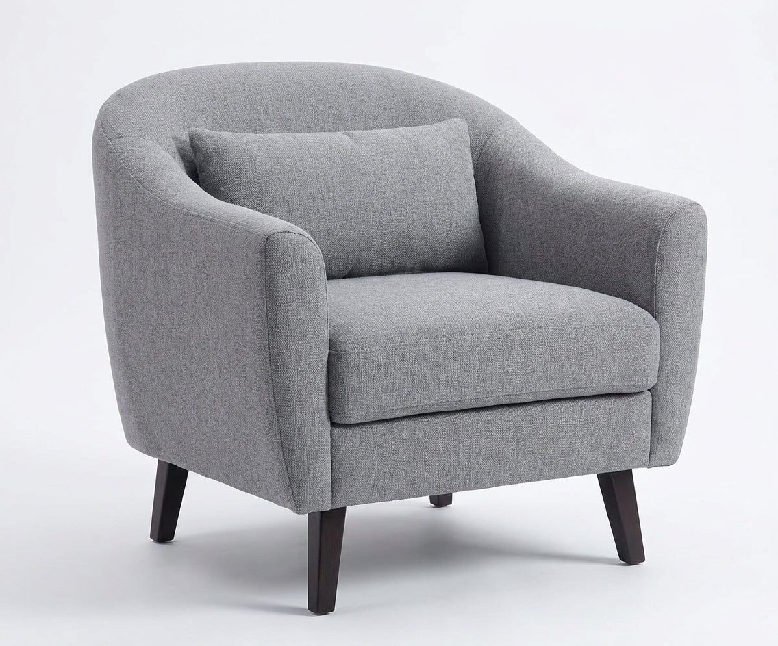 LC fabric lounge chair beside a sofa in a bright room with tall windows