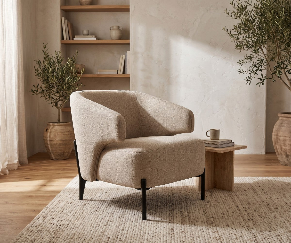 Light grey accent armchair with curved backrest styled in a luxurious, well-lit modern living room