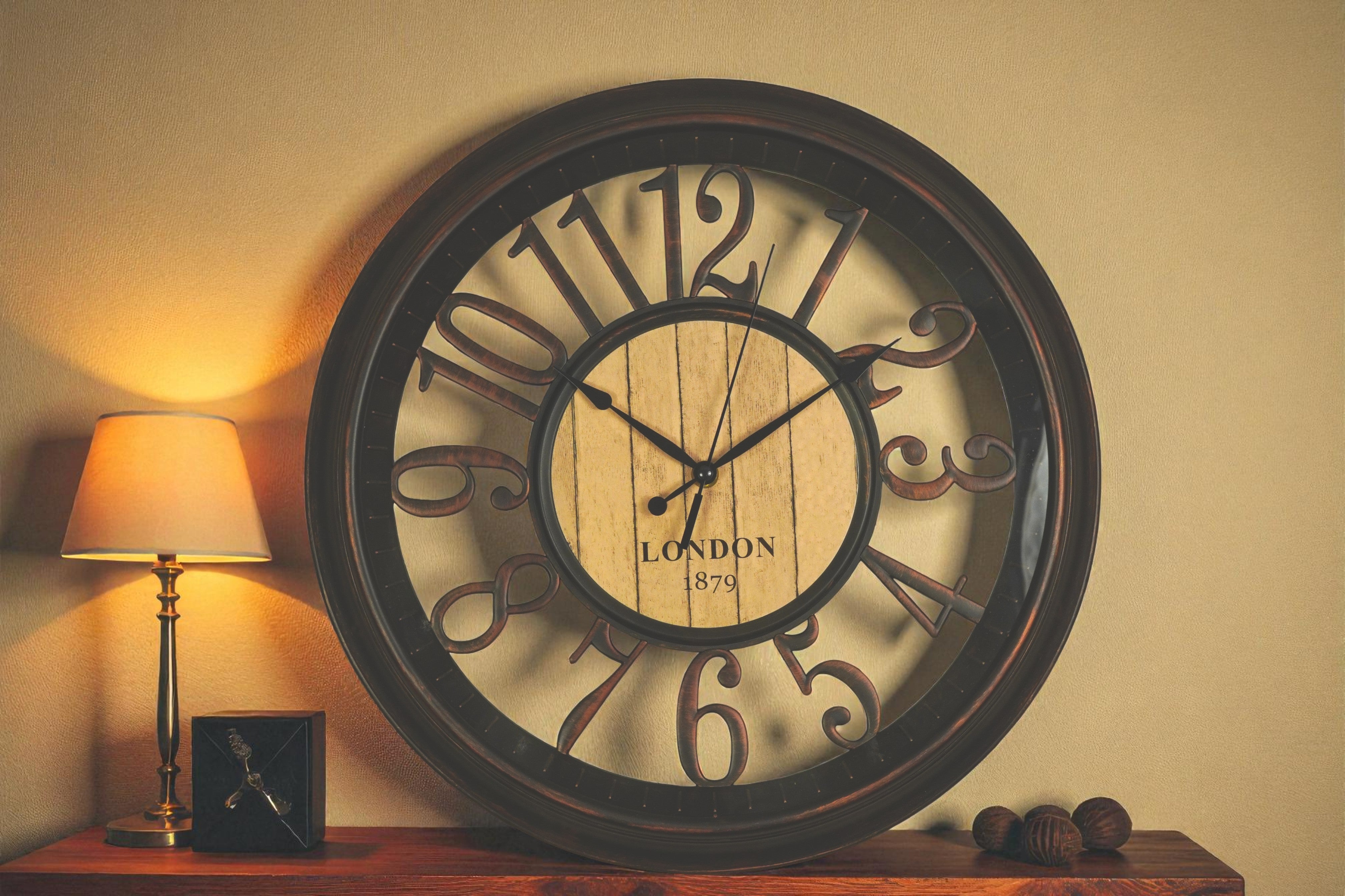 London 1879 bronze wall clock on a console beside a lit table lamp