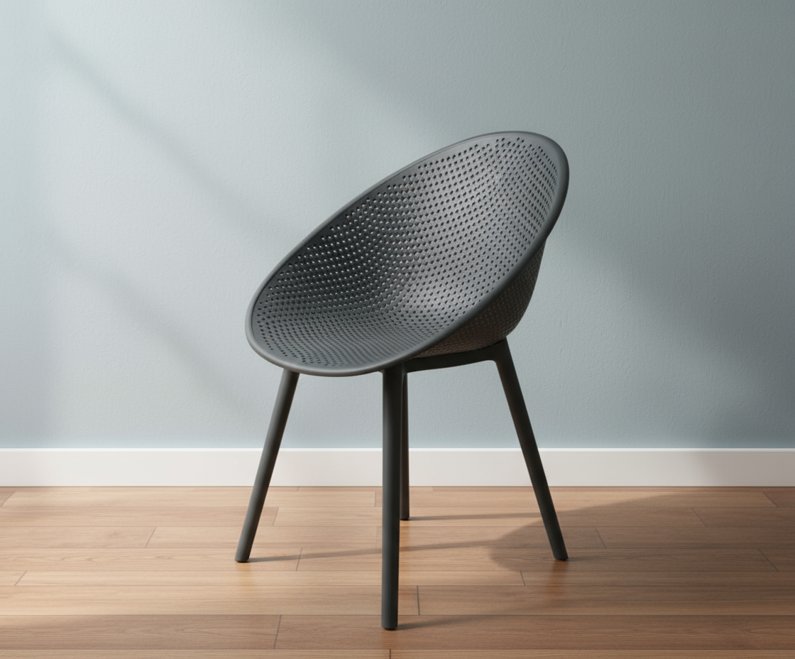 Lunar anthracite perforated designer chair, angled view on a wood floor