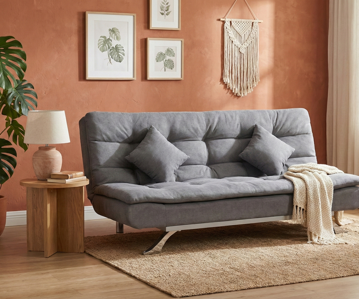 LV3364 armless sofa bed with scatter cushions against a terracotta wall