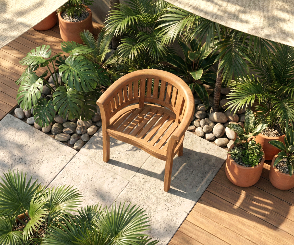 MARINA curved teak armchair, on a decked terrace among potted palms