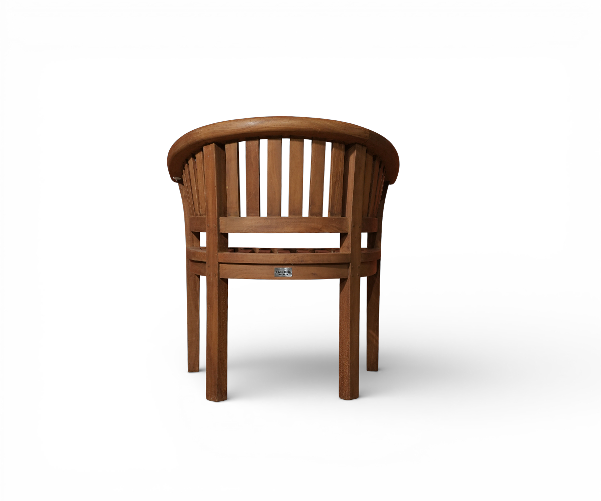 MARINA curved teak armchair, on a decked terrace among potted palms