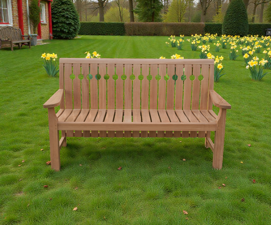 Maurice bench, teak garden bench on a lawn in front of daffodils