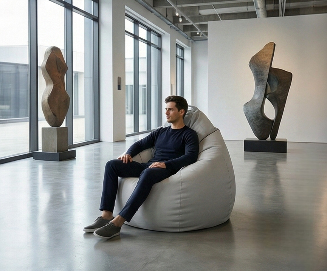 Modern Nordic bean bag in grey, with a person seated in a gallery space
