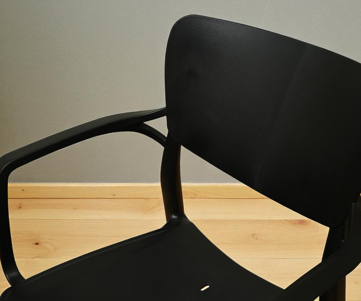 NVS-020-01 midnight modern designer armchair, angled view on a wood floor