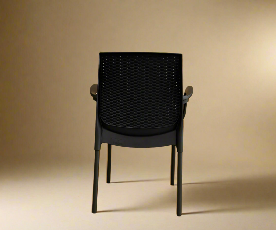 NVS-30-01 modern woven armchair in black, angled view against a warm wall