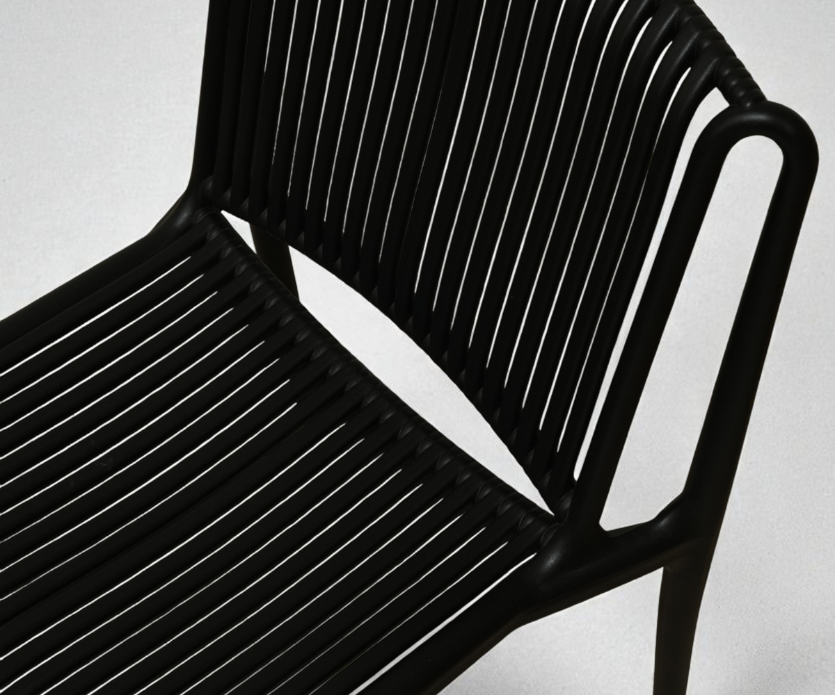 Onyx ribbed sculptural designer side chair, angled view in a spotlit setting