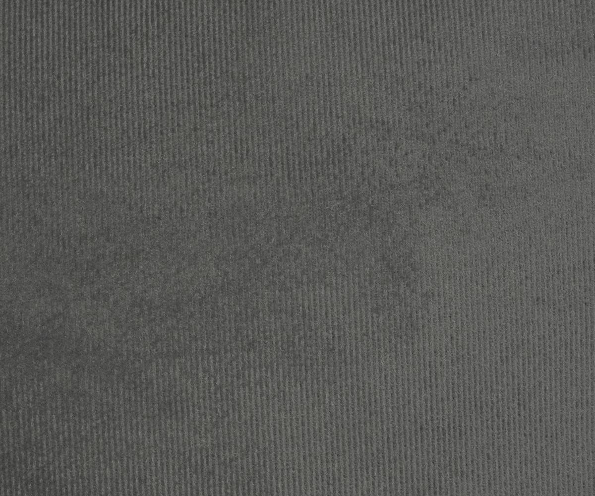 Slate faux fur cushion cover on a teal sofa in a dark panelled room