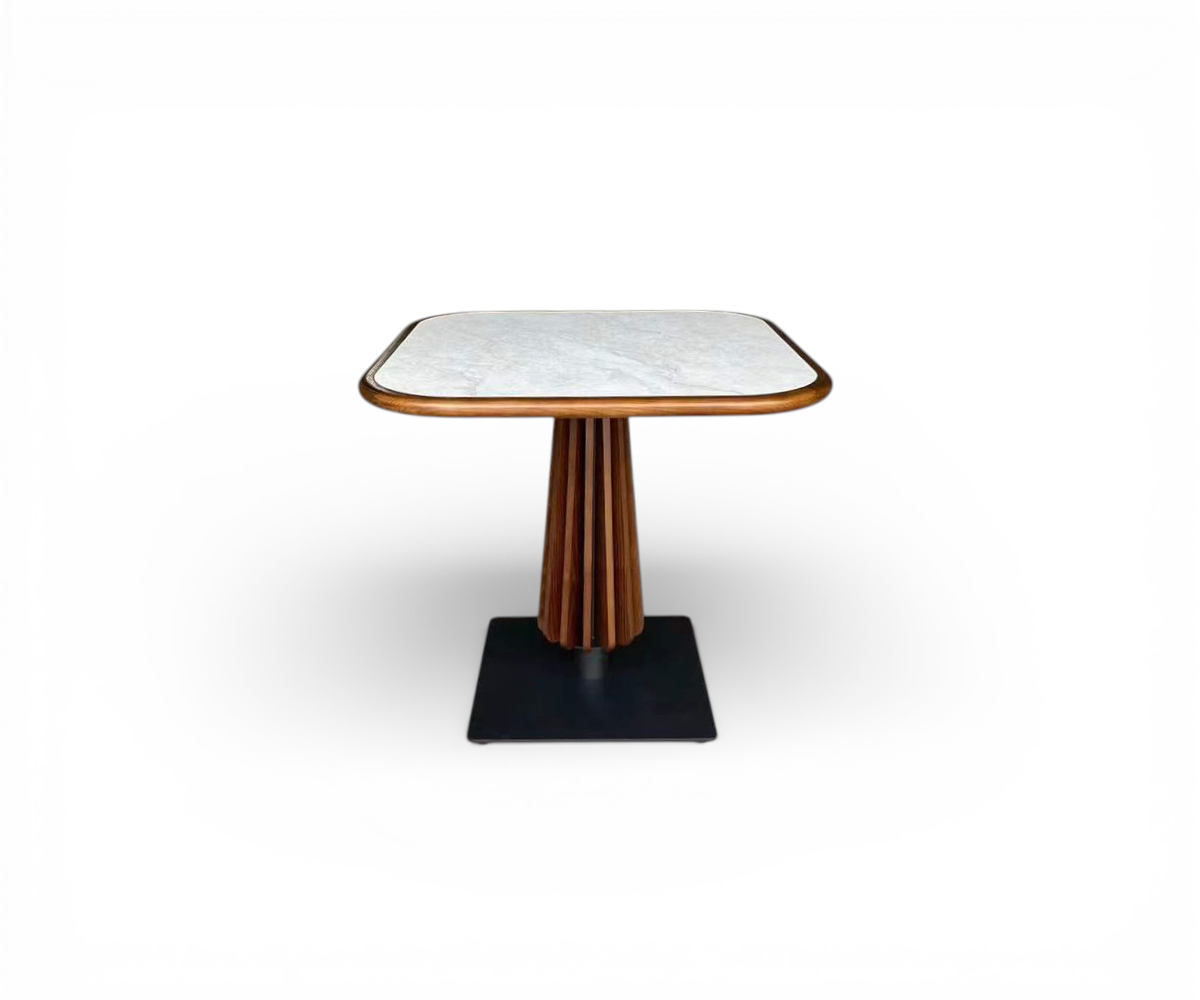 Solara pedestal table in a city-view restaurant beside green velvet chairs