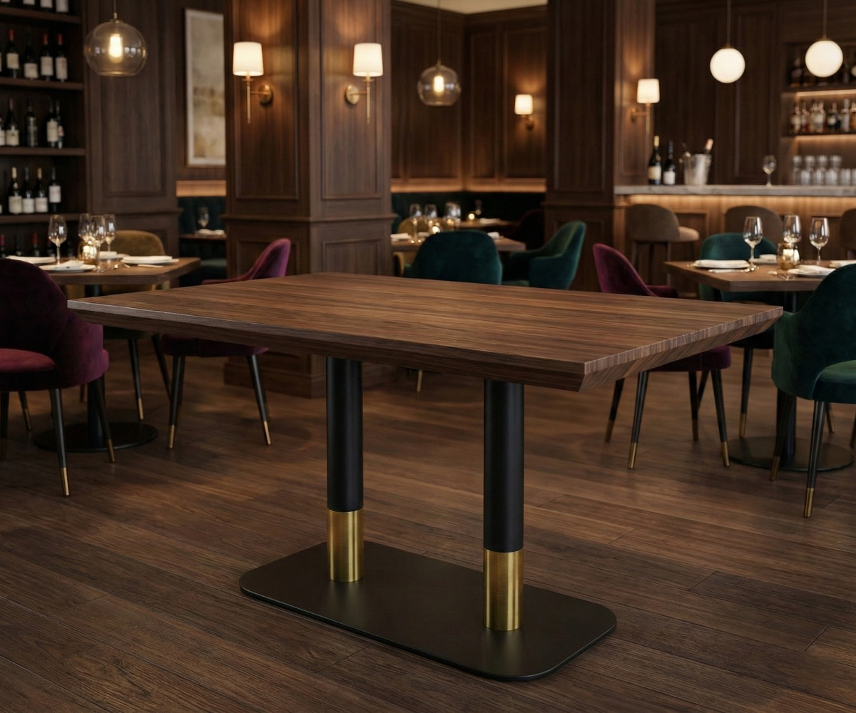 VANTAGE black and gold double pedestal table base in a warm-lit restaurant