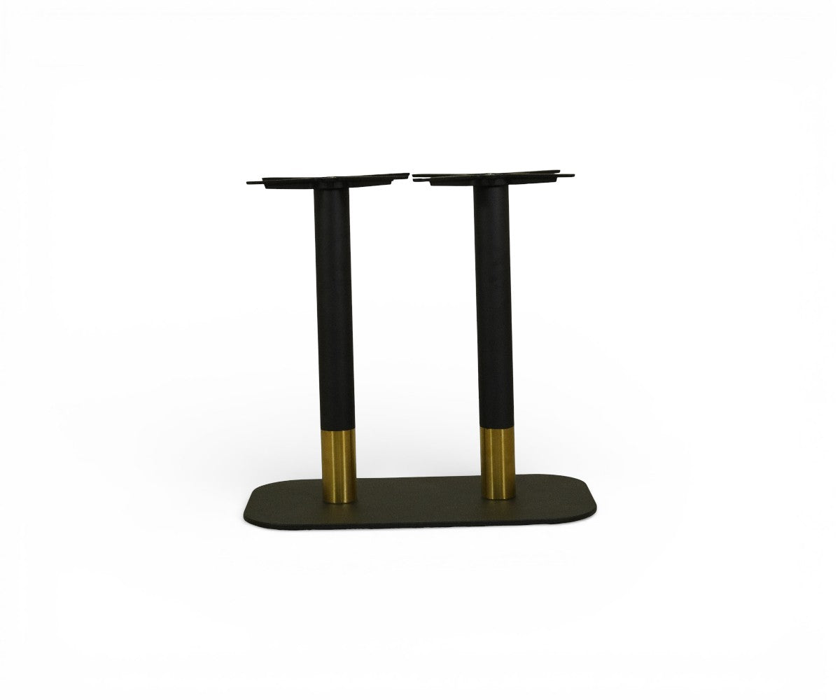 VANTAGE black and gold double pedestal table base in a warm-lit restaurant