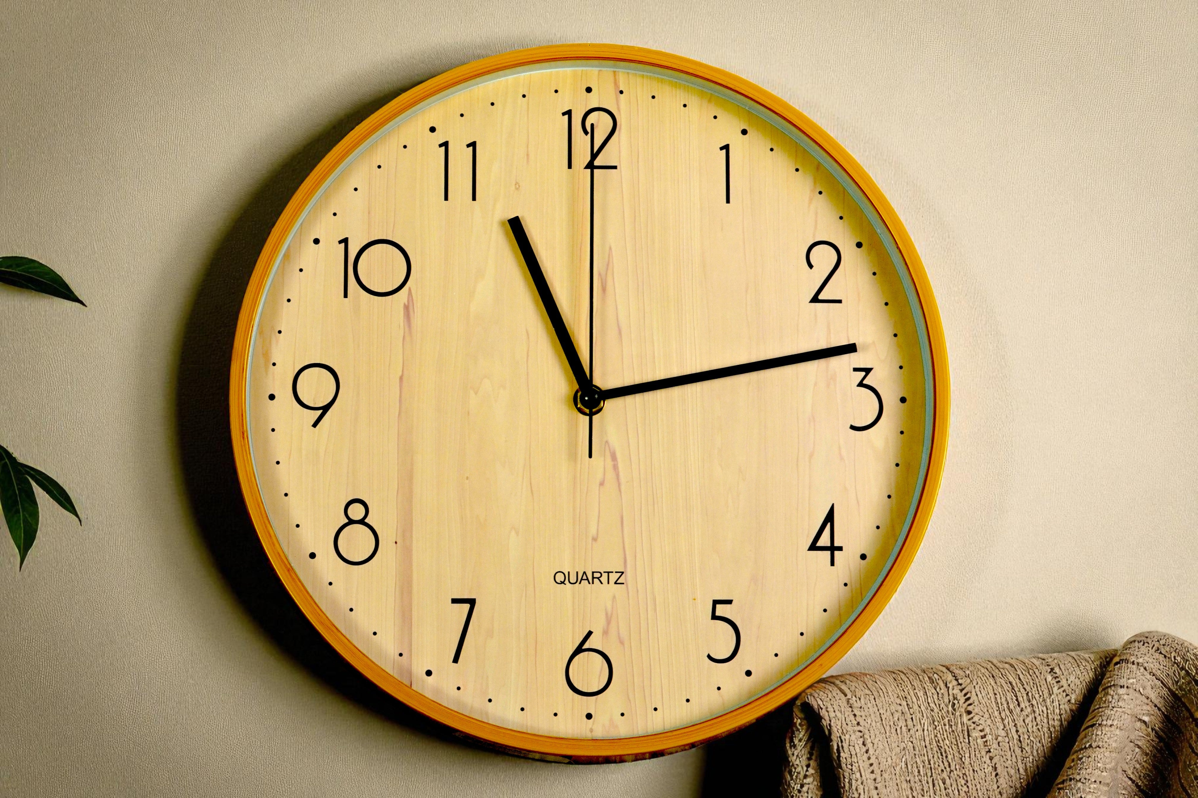 Wall Street natural wood wall clock on a cream wall beside a throw