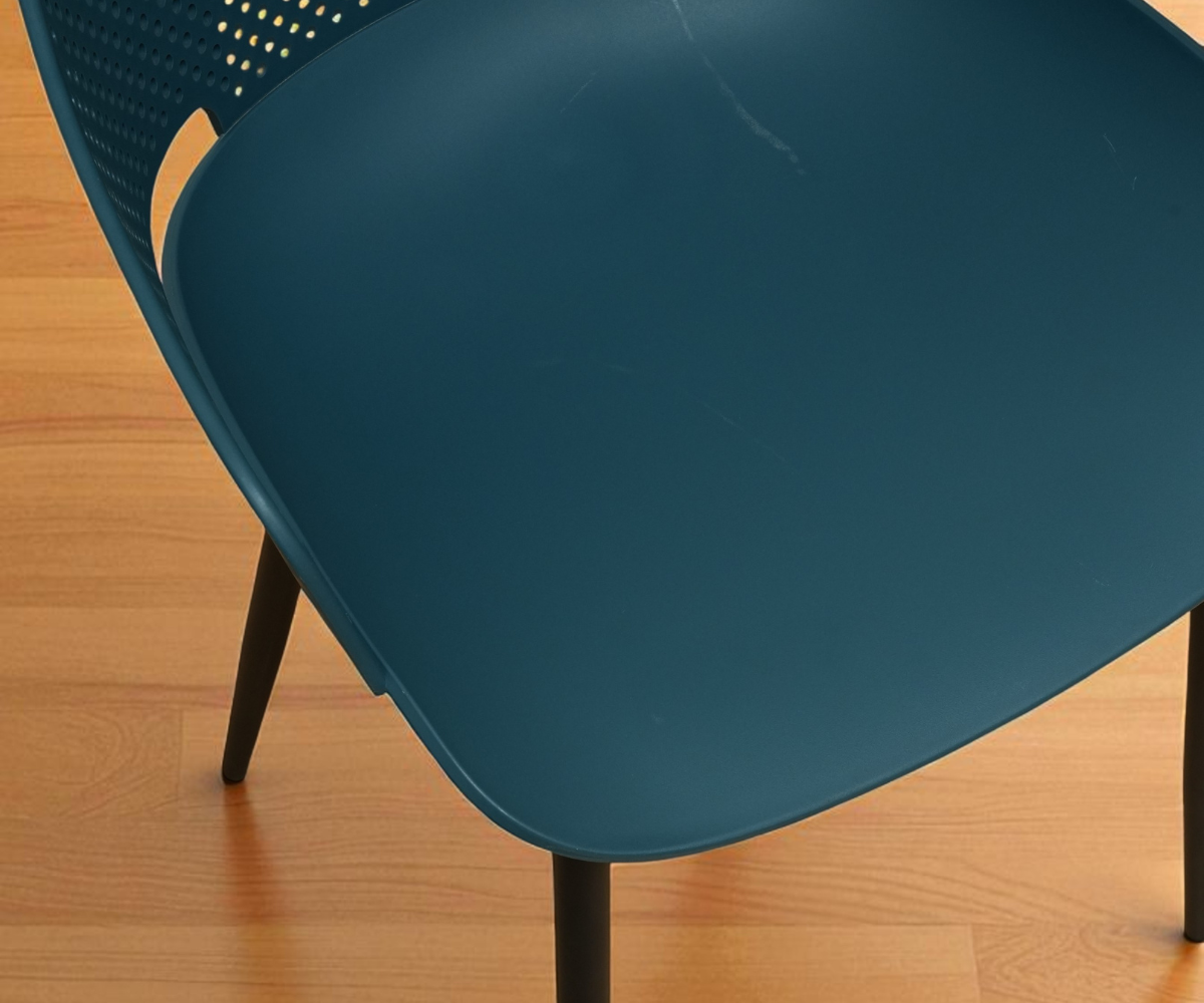 Zenith teal perforated designer armchair, angled view on a wood floor